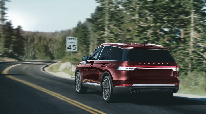 A 2024 Lincoln Aviator® SUV is being driven on a winding mountain road | Nick Mayer Lincoln Mayfield in Mayfield Heights OH