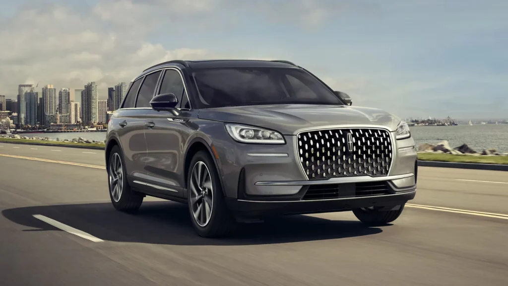 2025 Lincoln Corsair® SUV driving near city skyline with waterfront background.