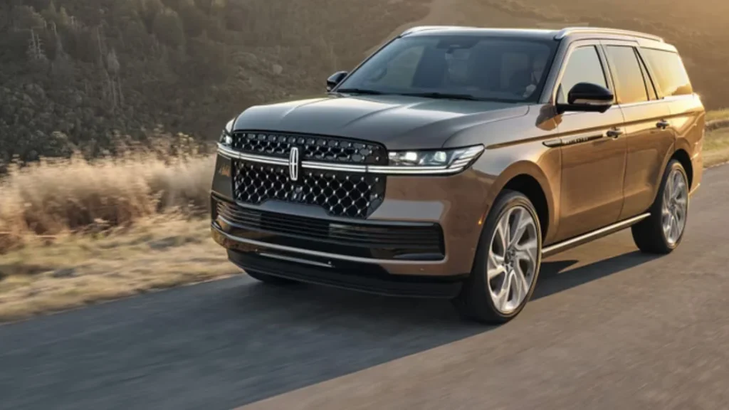 Bronze 2025 Lincoln Black Label Navigator® SUV cruising on a mountain road, showcasing its premium styling.