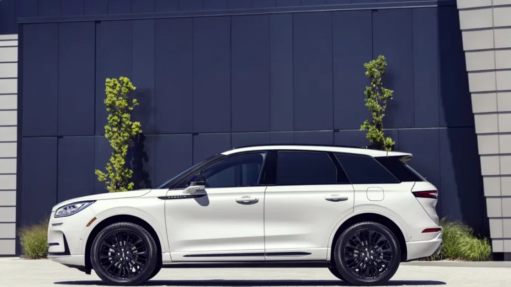 White 2025 Lincoln Corsair® Reserve viewed from the side, parked beside a modern building facade.
