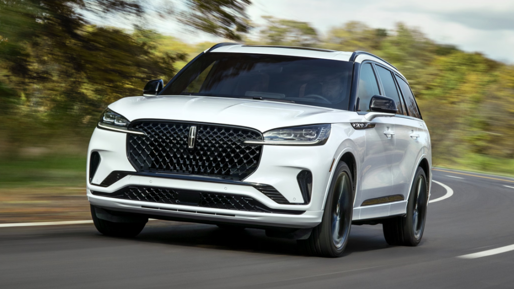 2025 Lincoln Aviator® Reserve white exterior front three-quarter driving on a curved road.