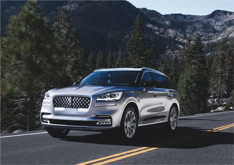 A 2023 Lincoln Aviator® Grand Touring SUV being driven on a winding road to demonstrate the capabilities of all-wheel drive | Nick Mayer Lincoln Mayfield in Mayfield Heights OH