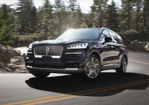 A Lincoln Aviator® SUV is being driven on a winding mountain road | Nick Mayer Lincoln Mayfield in Mayfield Heights OH