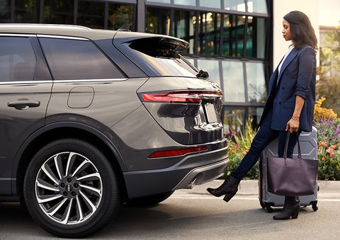 A woman with her hands full uses her foot to activate the available hands-free liftgate. | Nick Mayer Lincoln Mayfield in Mayfield Heights OH