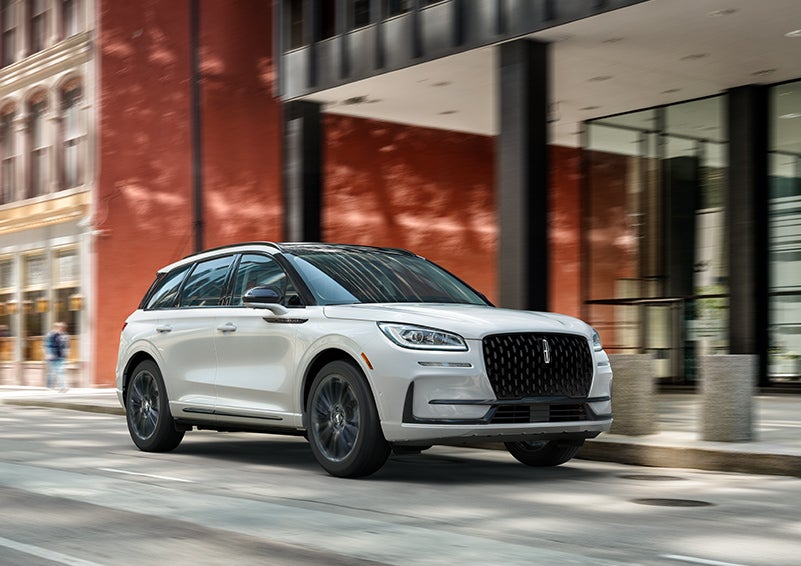 The 2024 Lincoln Corsair® SUV with the Jet Appearance Package and a Pristine White exterior is parked on a city street. | Nick Mayer Lincoln Mayfield in Mayfield Heights OH
