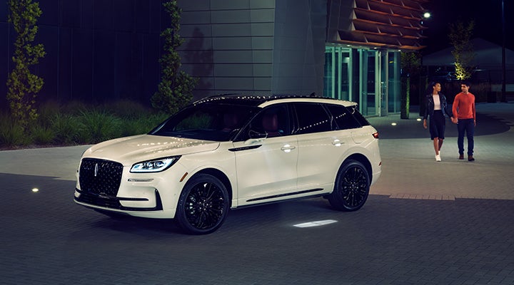 Two people approach a 2024 Lincoln Corsair® SUV featuring the available Jet Appearance Package. | Nick Mayer Lincoln Mayfield in Mayfield Heights OH