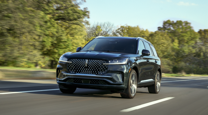 A 2025 Lincoln Black Label Aviator® SUV is being driven down a road lined with trees. | Nick Mayer Lincoln Mayfield in Mayfield Heights OH