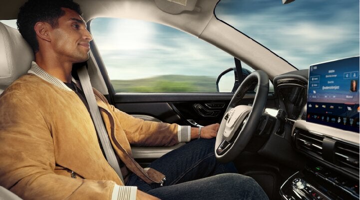 A person is shown using Lincoln BlueCruise hands-free highway driving technology on a divided highway called a Hands-Free Blue Zone. | Nick Mayer Lincoln Mayfield in Mayfield Heights OH