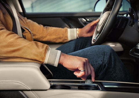 The driver of a 2024 Lincoln Corsair® SUV is shown selecting the drive mode. | Nick Mayer Lincoln Mayfield in Mayfield Heights OH