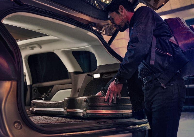 A man is shown loading cargo into the rear of a 2024 Lincoln Corsair® SUV with the second-row seats folded flat. | Nick Mayer Lincoln Mayfield in Mayfield Heights OH