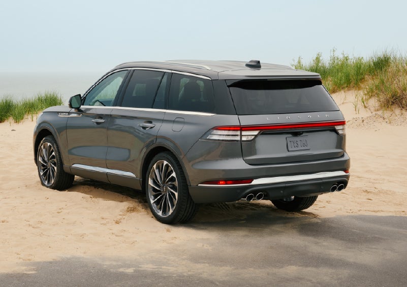 A 2027 Lincoln Aviator® SUV is parked next to sand dunes. | Nick Mayer Lincoln Mayfield in Mayfield Heights OH