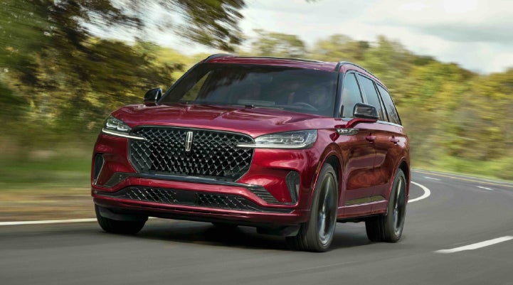 A 2027 Lincoln Aviator® SUV is being driven on a country road | Nick Mayer Lincoln Mayfield in Mayfield Heights OH