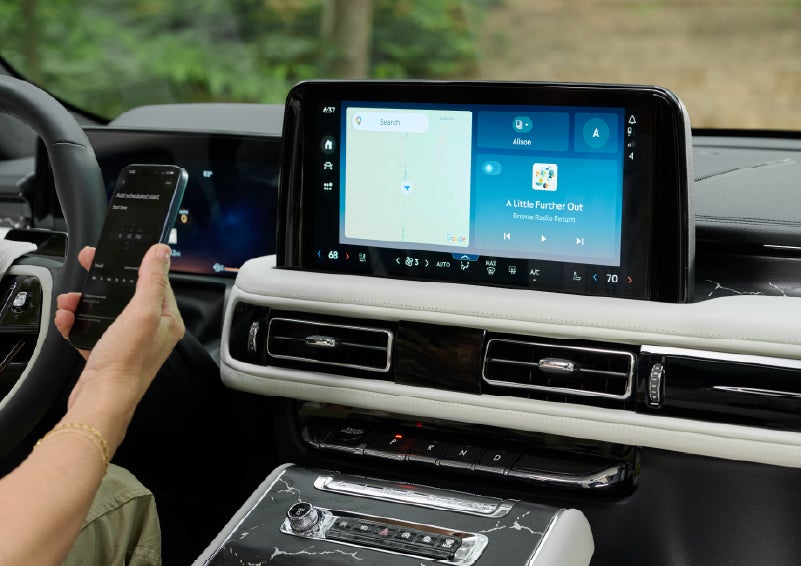 A person pairs thier phone with the center touchscreen of a 2027 Lincoln Aviator® Black Label™ SUV | Nick Mayer Lincoln Mayfield in Mayfield Heights OH