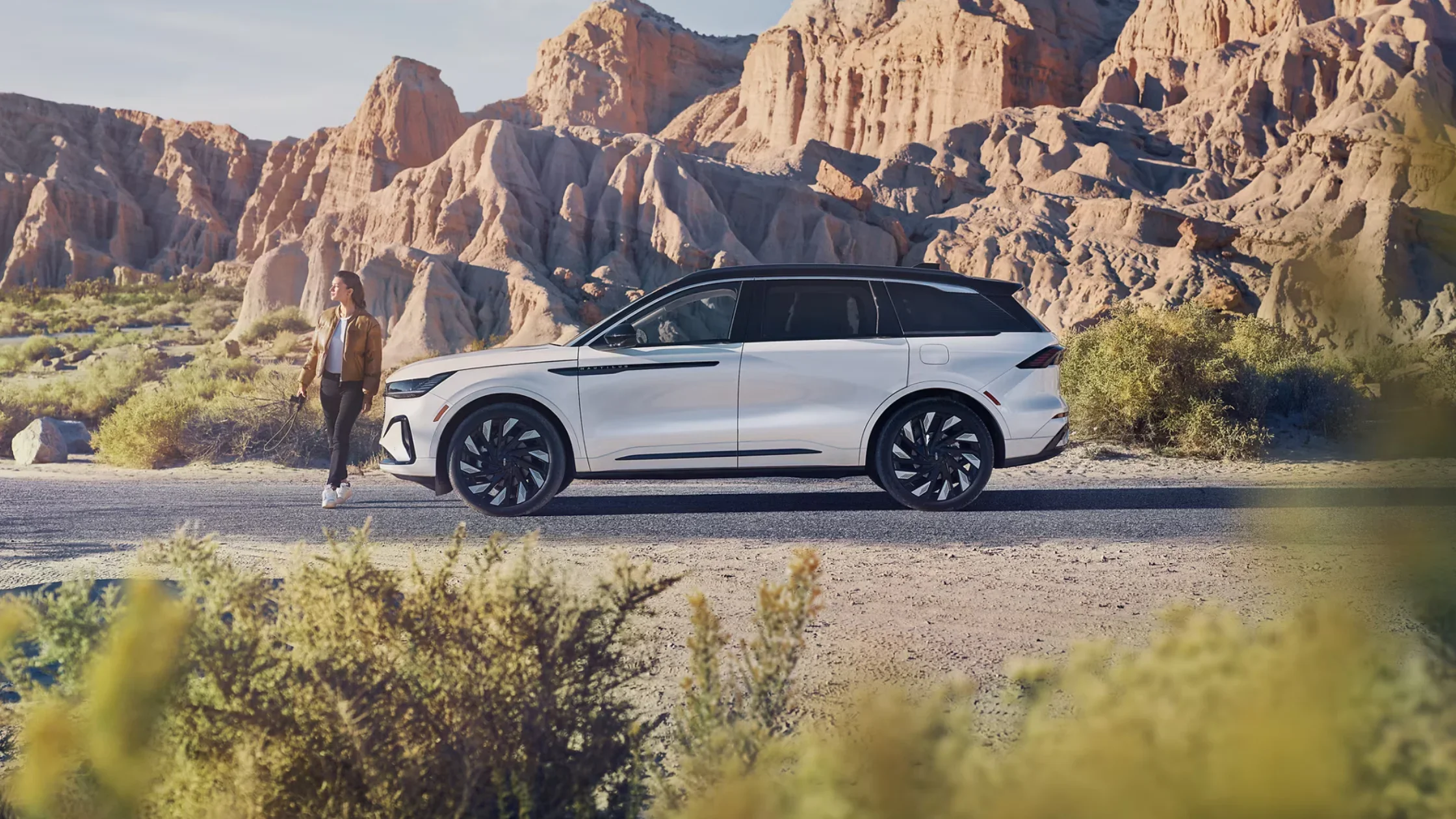 White 2025 Lincoln Black Label Nautilus SUV parked in desert landscape with modern black wheels.