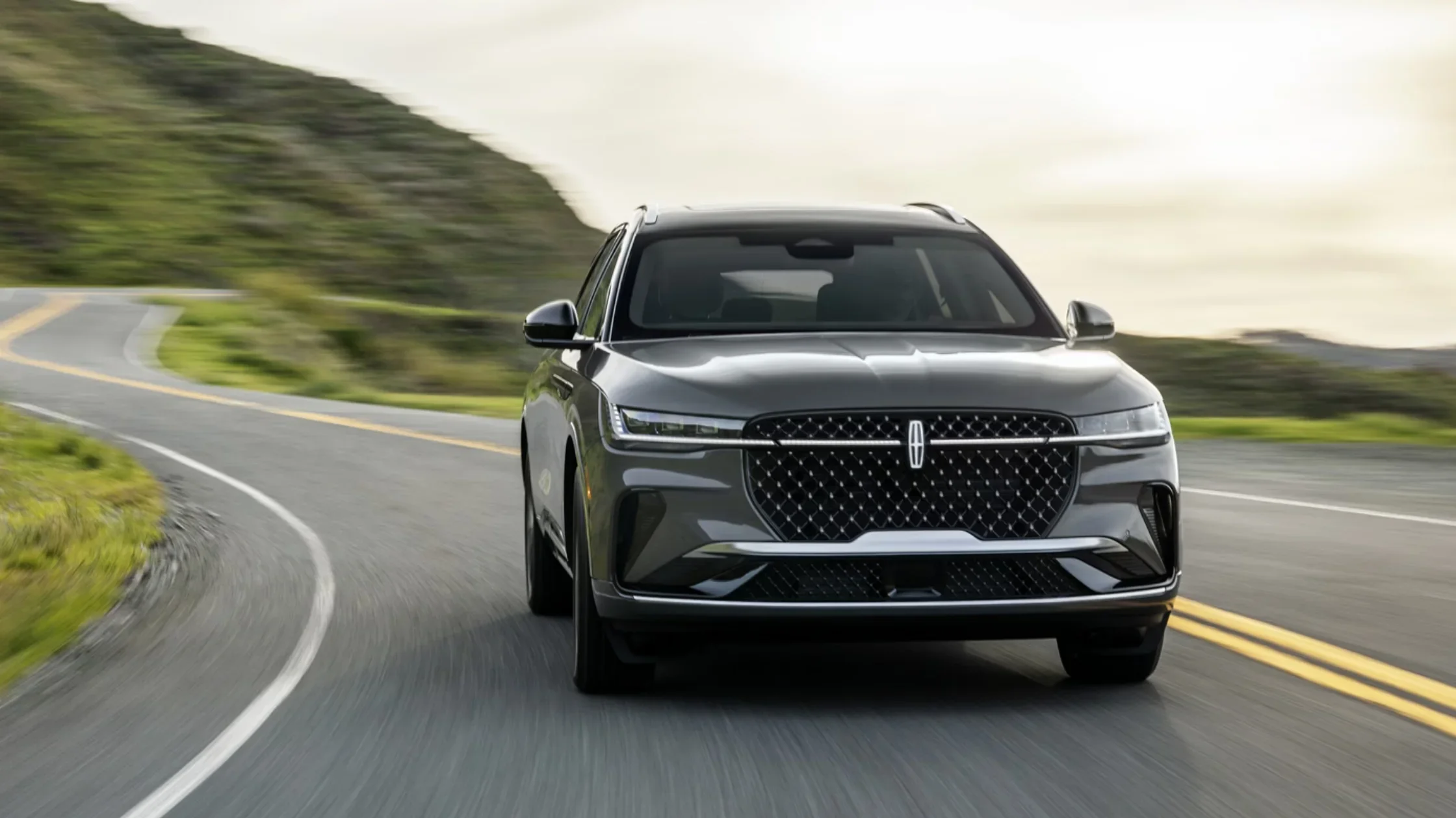 2026 Lincoln Nautilus® exterior front view driving on scenic highway.