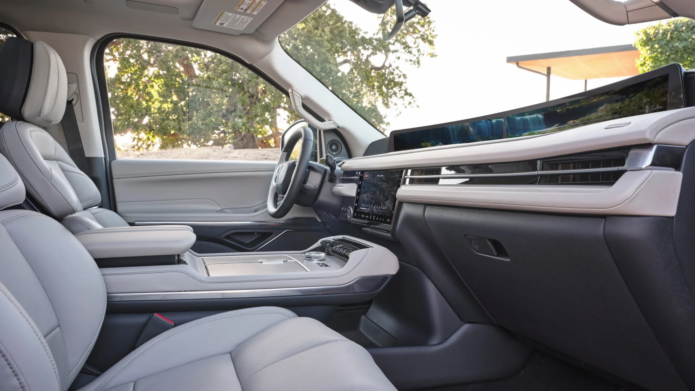 A close-up of the 2025 Lincoln Navigator® Reserve’s center console, featuring premium wood trim, a rotary gear selector, and polished control buttons for driving modes and infotainment.