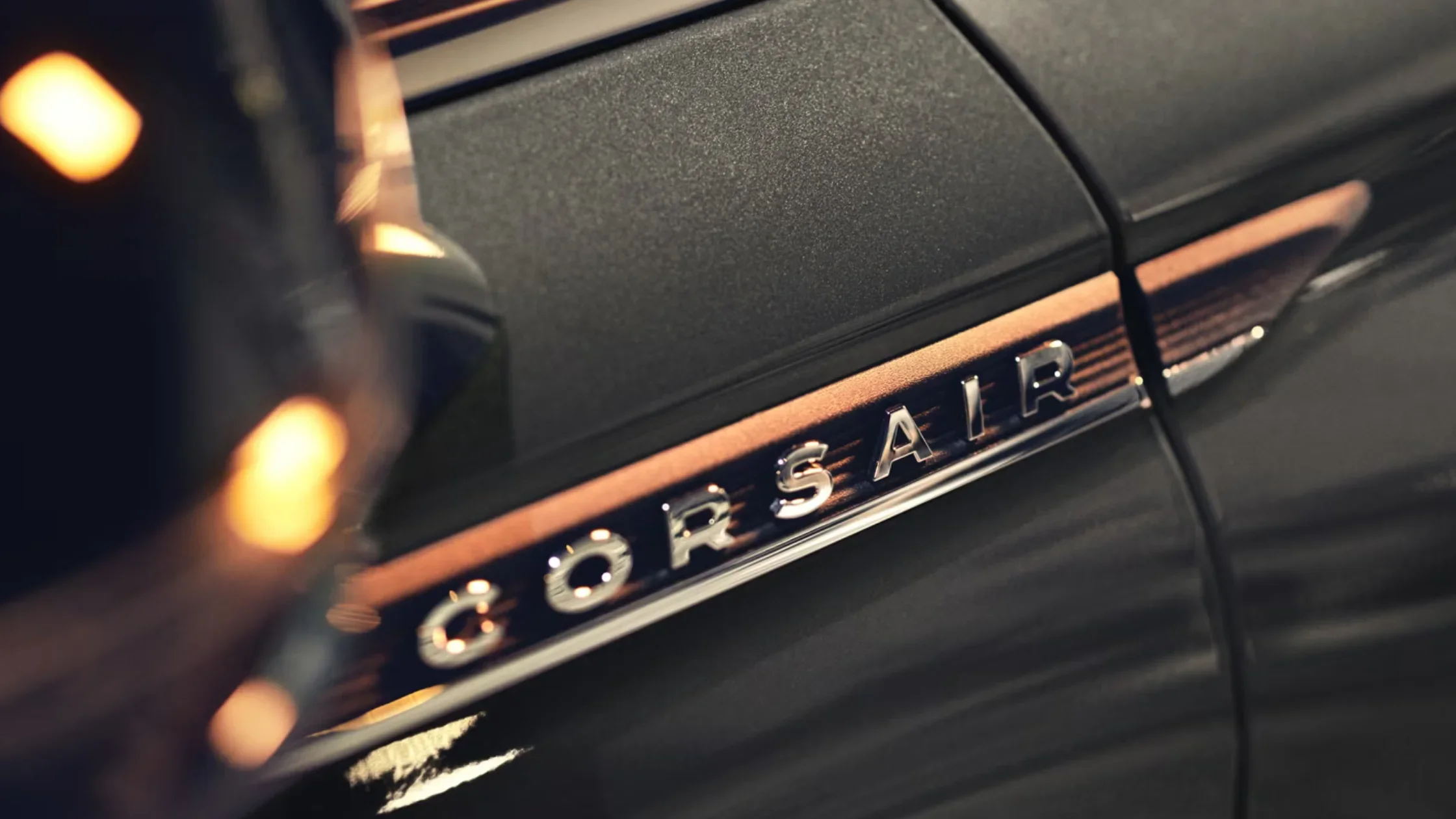 Close-up of the 2025 Lincoln Corsair® copper-accented side badge on metallic black exterior