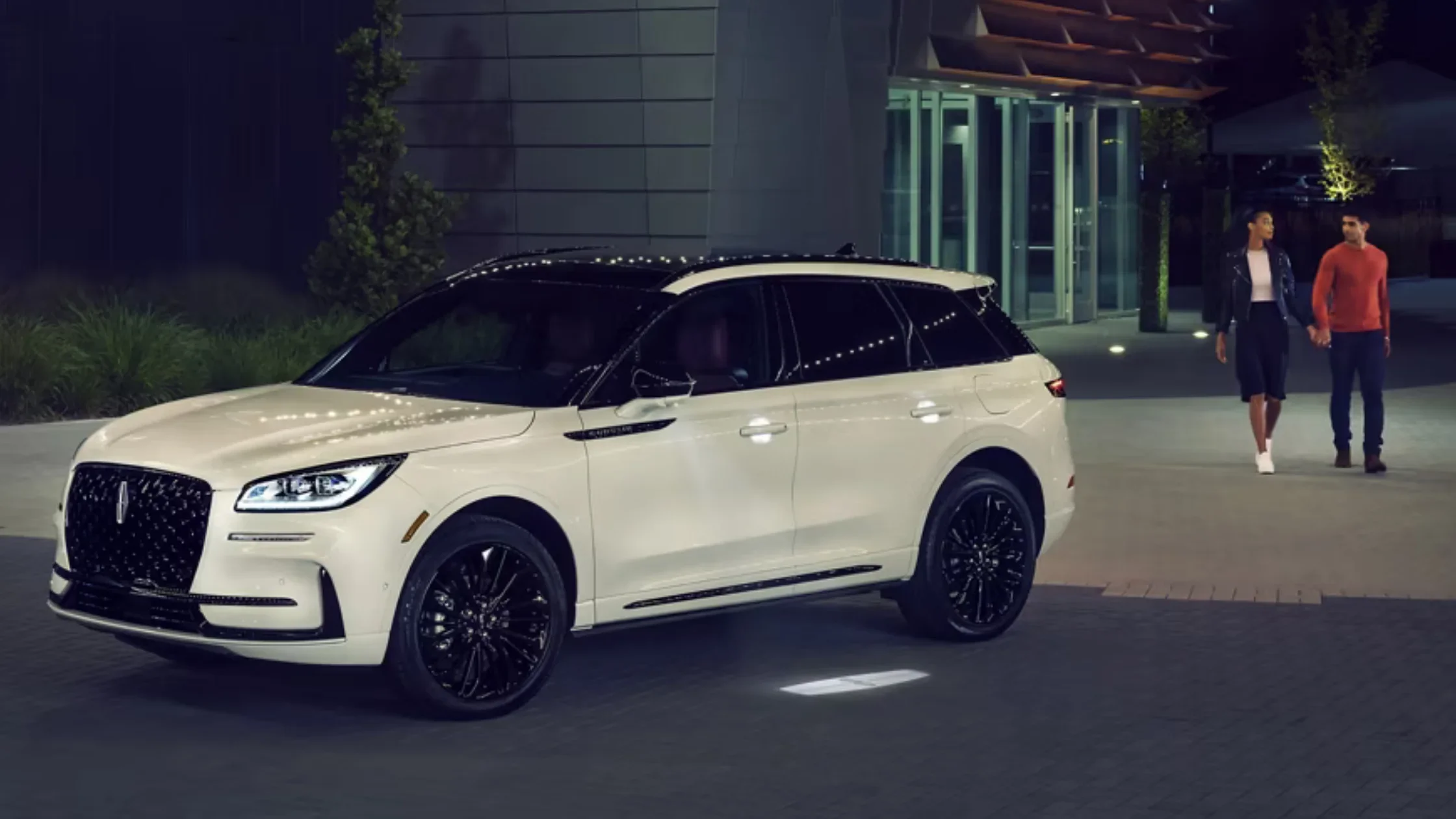 2025 Corsair Reserve white SUV parked at night with illuminated exterior and black wheels.