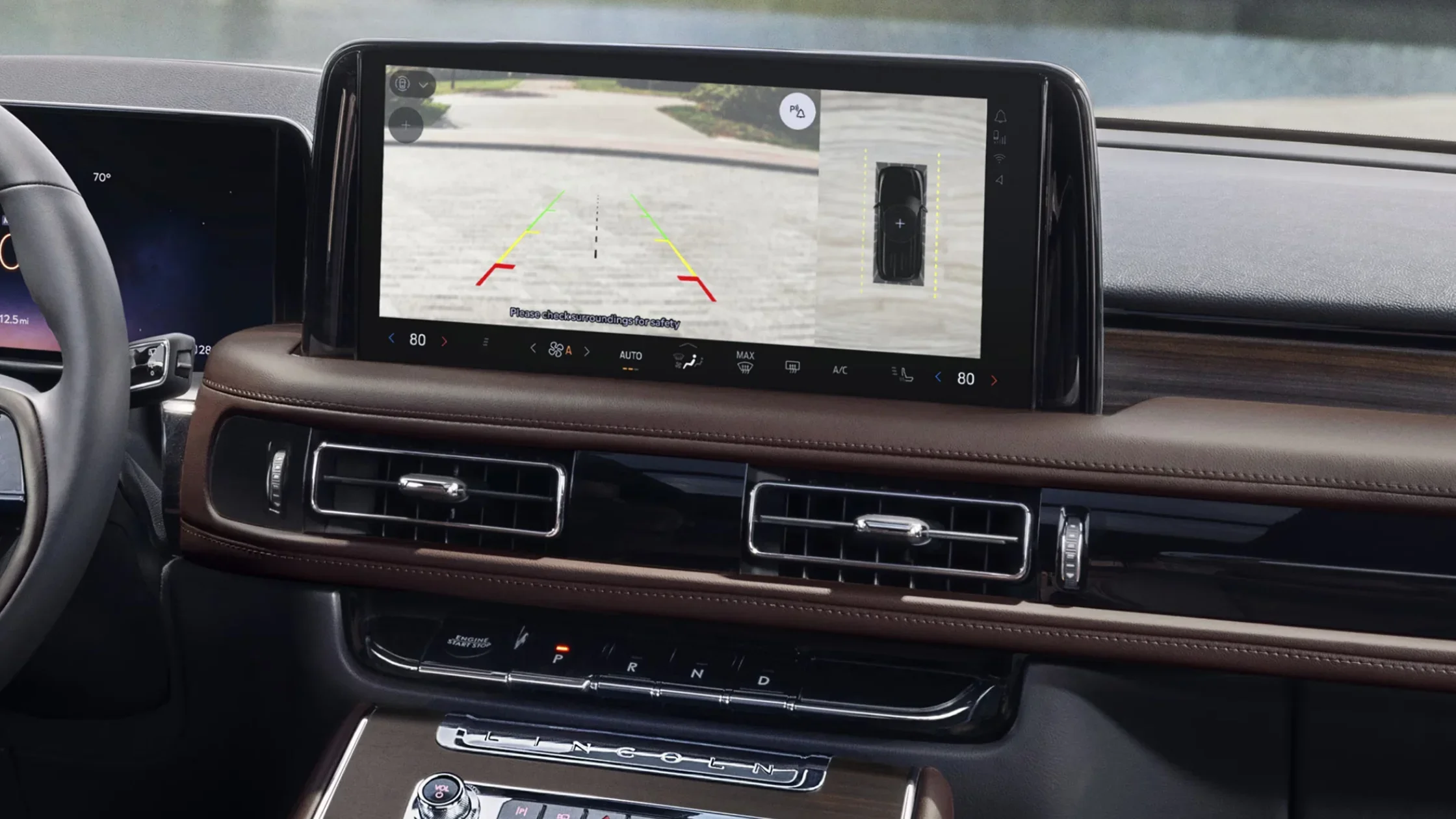 2025 Lincoln Black Label Aviator parking assist technology shown maneuvering between vehicles near modern building.