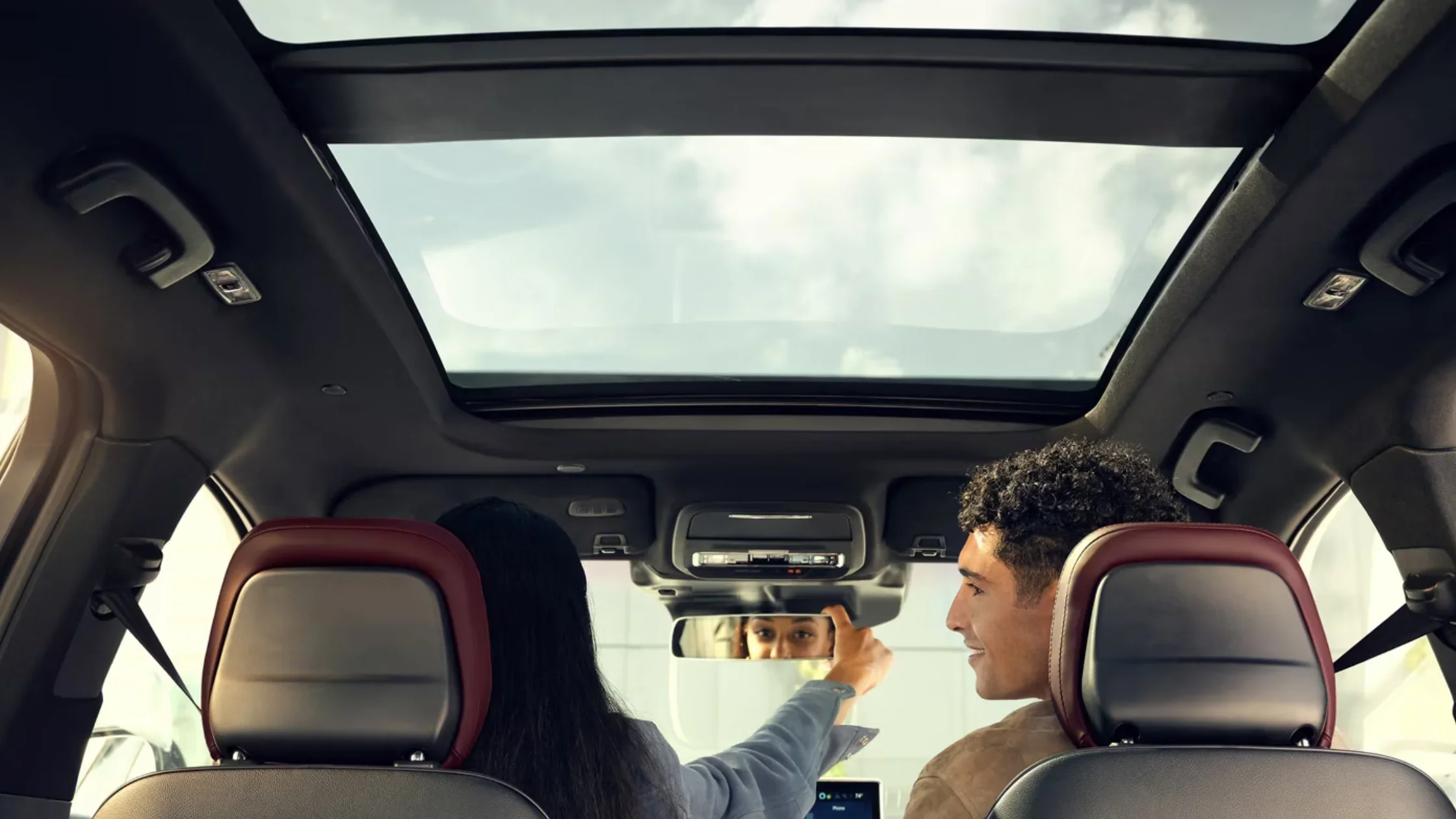 2025 Corsair® Grand Touring panoramic sunroof view with passengers adjusting mirror.